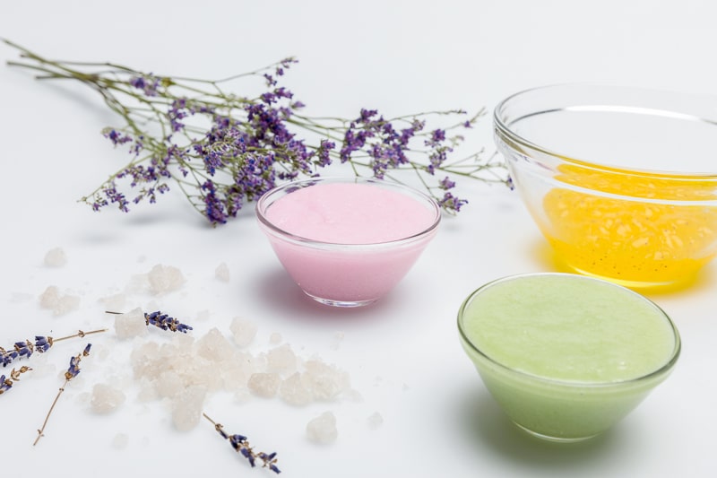 Homemade beauty products in glass bowls with lavender next to them