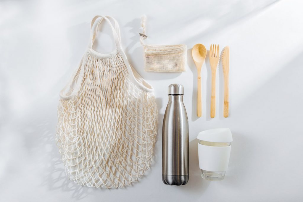 Wooden utensils reusable water bottle coffee mug and grocery bag how to reduce plastic waste at home reviving simple