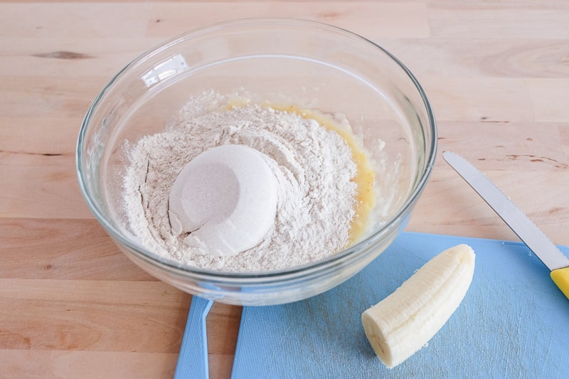 flour in bowl on wooden table with banana vegan buckwheat banana pancakes