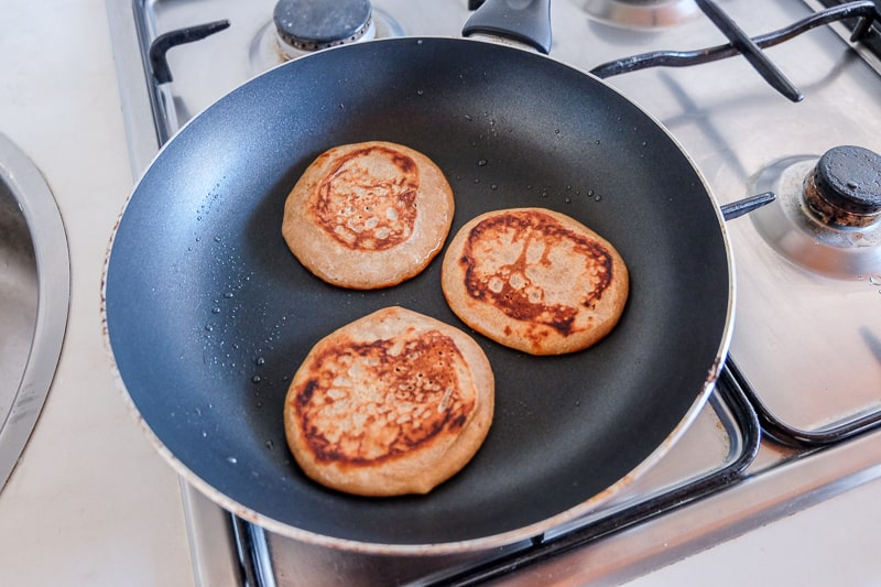 flipped over pancakes in frying pan vegan buckwheat banana pancakes