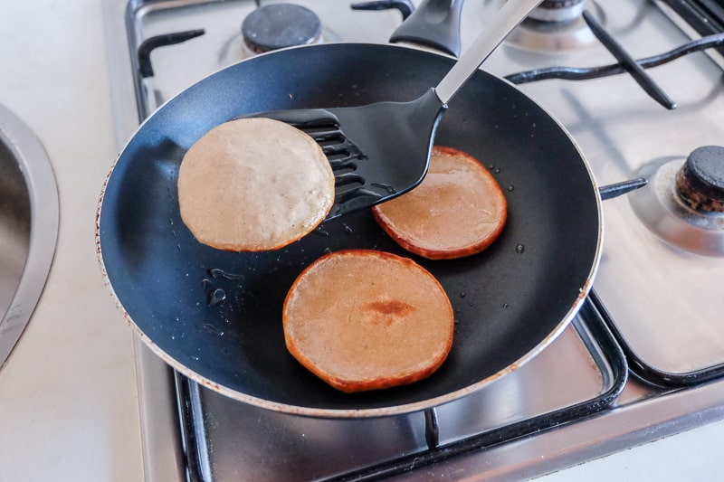 pancakes and flipper with frying pan on stove vegan buckwheat banana pancakes